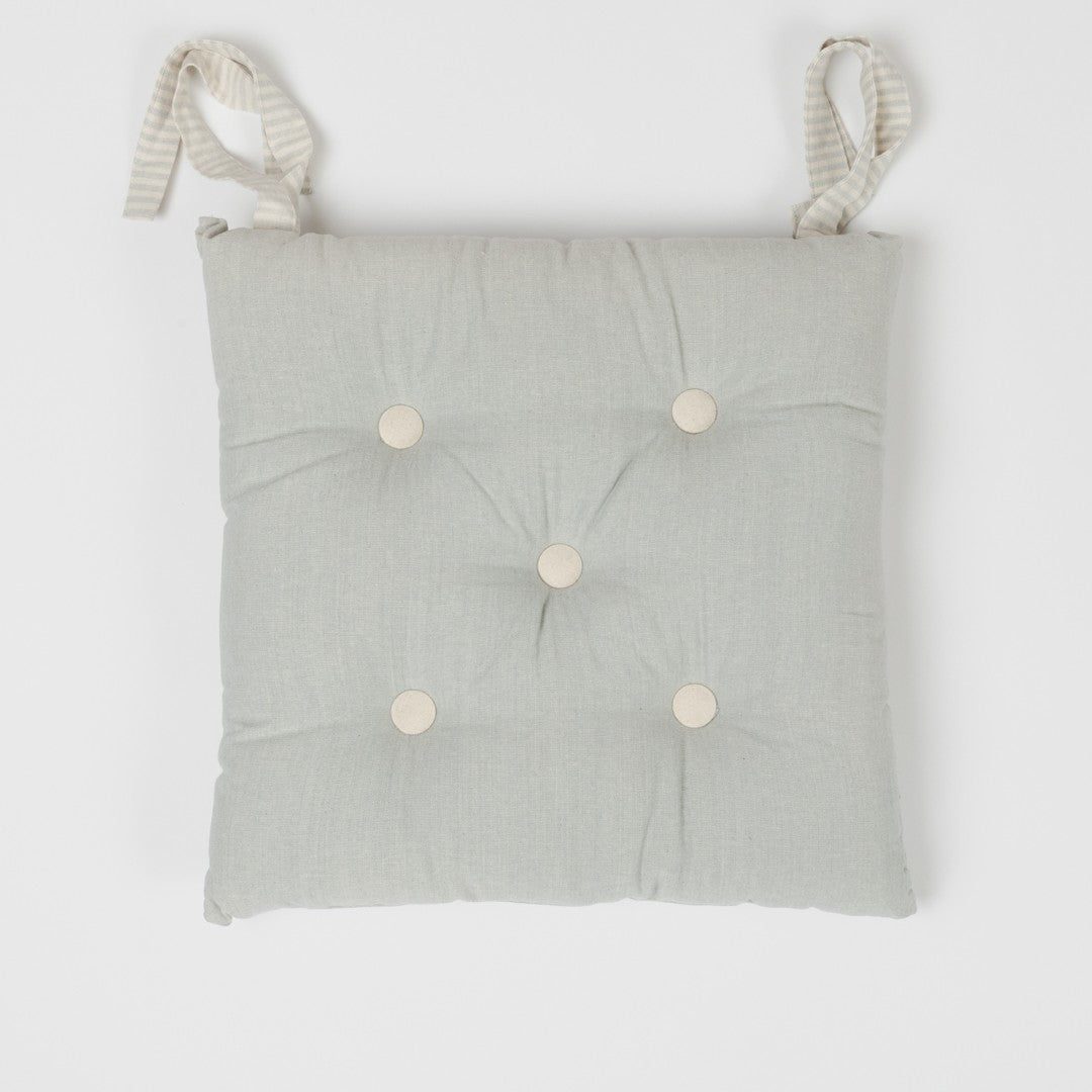 Almofada de algodão simples com botões e ferro de passar.