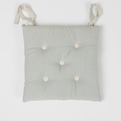 Almofada de algodão simples com botões e ferro de passar.